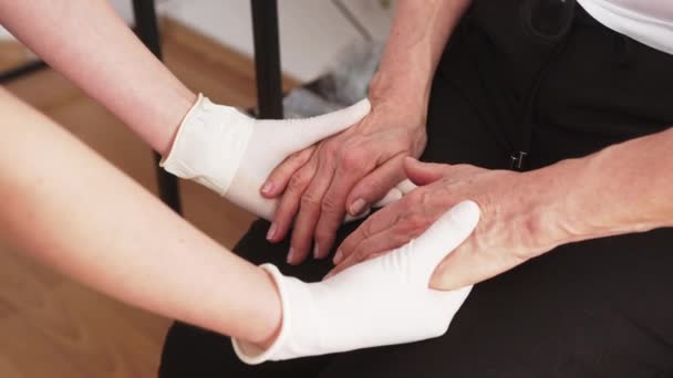 Close-up de enfermeira cuidadora caucasiana e mulher idosa de mãos dadas. Apoio aos cuidados de saúde. — Vídeo de Stock