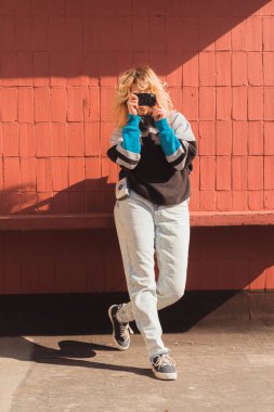 90 'ların reklamı. Kafkasyalı genç fotoğrafçı eski moda analog kamerayla fotoğraf çekiyor. Dikey çekim.