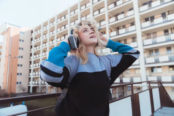 Drömmande och bekymmerslös ung europeisk tjej på 90-talet lyssnar på sitt favoritalbum på sin gammaldags musikspelare. — Stockfoto