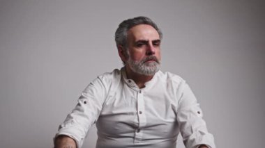 Gri saçlı adam aniden kötü bir haber aldı ve gerçekten üzgün hissetmeye başladı, başını öne eğdi.