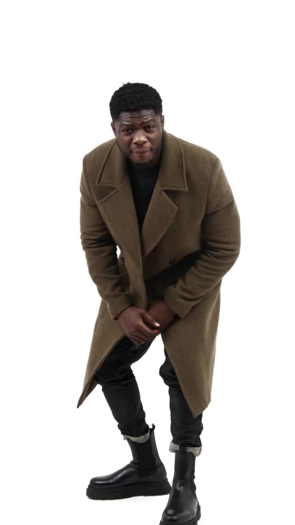 Young black male looking arond trying to find the best angle and then rubbing his hands, white background, vertical — Stock Video