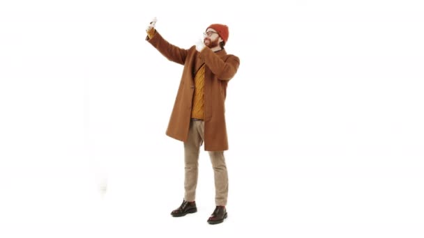 Positiv ung vit man tar selfie, visar bit skylten till kameran och ler isolerad vit bakgrund full shot kopia utrymme — Stockvideo