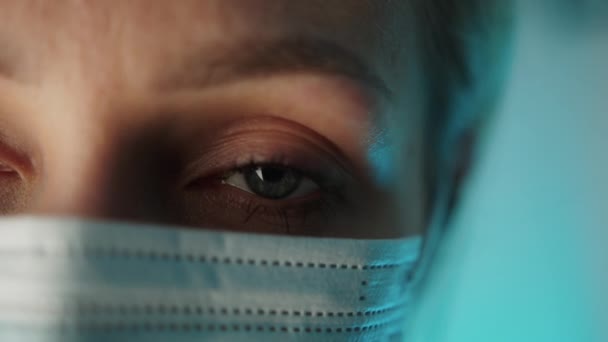 Närbild av porträttet. Den unga kvinnliga läkarens öga. Skydd mot smittsam sjukdom genom att bära hygienisk ansiktskirurgisk medicinsk mask. — Stockvideo