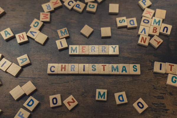 Фраза MERRY CHRISTMAS из разбросанных деревянных букв концепция зимних праздников 