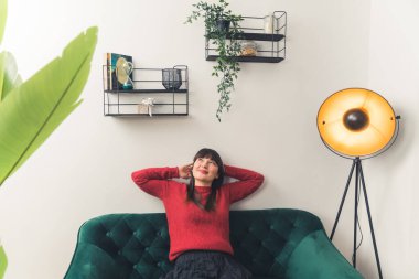 Güzel beyaz kadın evdeki kanepede uzanarak rahatlıyor. Bireysellik kavramı.