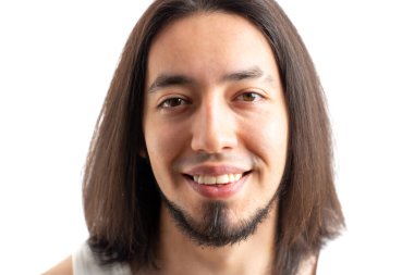 Kameraya bakıp dişlek gülümsemesini gösteren sakallı, uzun saçlı beyaz bir adamın stüdyo portresi. Beyaz arkaplan üzerinde izole edilmiş.