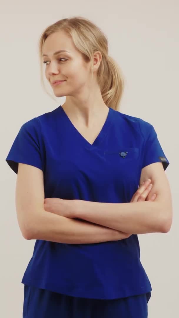 Verticale Video - sfondo bianco medico chirurgo femminile guardando da parte e incrociando le braccia. — Video Stock
