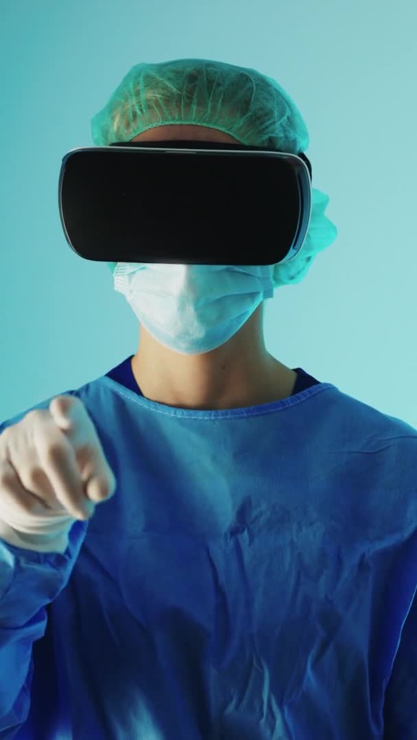 Wideo pionowe - Lekarz w okularach VR i pełnym mundurze ochronnym dotykający palcem powietrza. Koncepcja nowoczesnej technologii. — Wideo stockowe