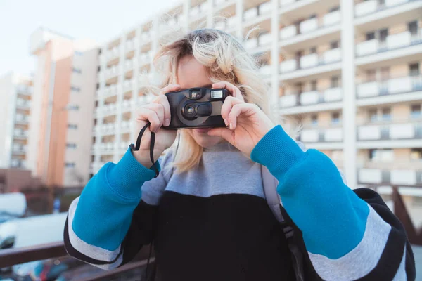 金发碧眼的高加索女孩正在使用老式的模拟相机。90年代的氛围和时尚. — 图库照片