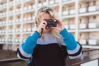 Klasik analog kamera. 90 'ların titreşimleri. Orta boy açık hava çekimi. Arkaplanda apartman bloğu.