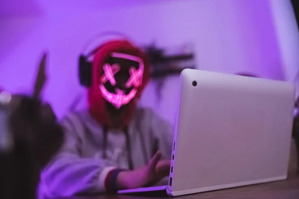 Опасный хакер в маске с помощью ноутбука. Концепция безопасности. — стоковое фото