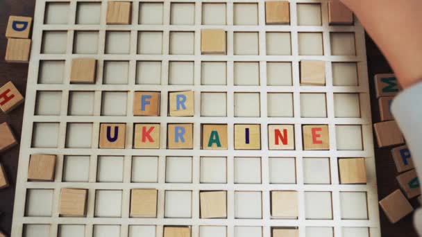 La palabra UCRANIA GRATUITA hecha de bloques de madera juego de vocabulario jugador caucásico — Vídeos de Stock
