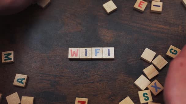 Word WI-FI gjord av träklossar med bokstäver Vit spelare som samlar klossar runt — Stockvideo