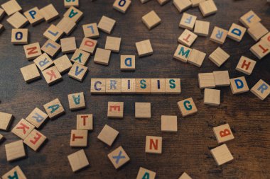 KRISIS kelimesi, harflerle sıralanmış tahta bloklardan oluşur. Kelime oyunu ekonomik sorunlar kavramı. 