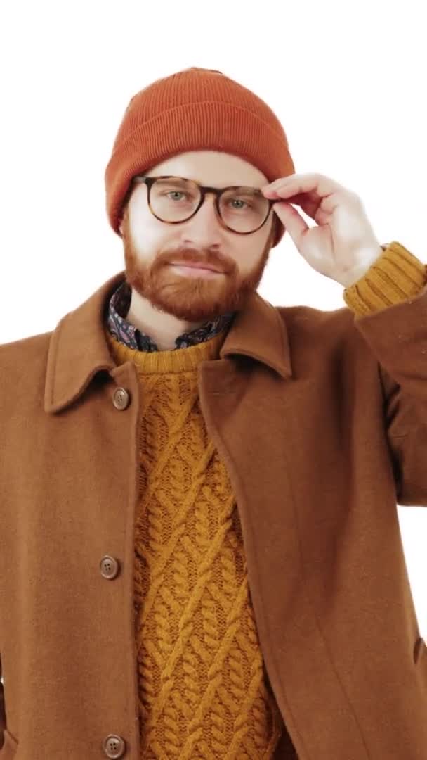 Encantador hombre millennial ajusta sus gafas y se las quita más tarde vertical video blanco fondo aislado estudio disparo — Vídeo de stock