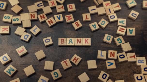 Sebuah kata BANK terbuat dari huruf kayu permainan kosakata tabungan dan konsep anggaran — Stok Video