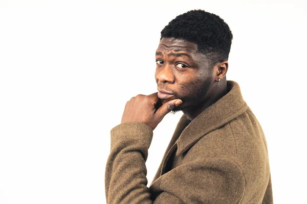 Suspicious black guy with his hand on the chin white background - close-up shot —  Fotos de Stock