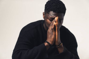 Yüzünde elleri olan endişeli siyah adam beyaz arka plan - yakın çekim