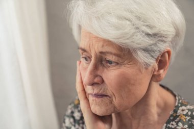 portrait of an elderly pensioner woman suffering from dementia and being depressed close up shot