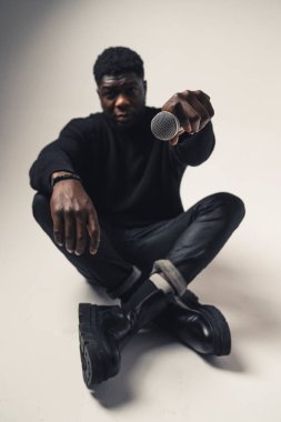 Siyah adam mikrofonu beyaz arka planda gösteriyor. Tam çekim.