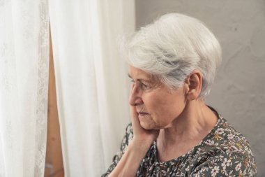Son derece endişeli ve üzgün, gri saçlı büyükanne ve büyükbaba gününde tek başına. Yakın çekim.
