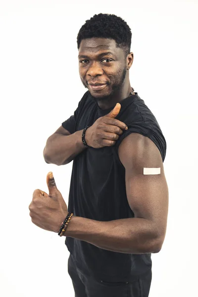 Χαμογελαστός μαύρος άνδρας δείχνει το εμβόλιο με τους αντίχειρες επάνω - πορτρέτο πυροβόλησε — Φωτογραφία Αρχείου