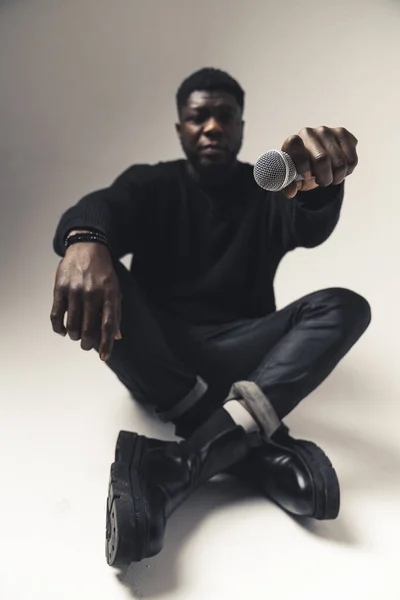 African American holding microphone in focus blur background - full shot —  Fotos de Stock