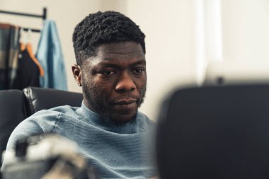 Evde tablet bilgisayar üzerinde çalışan odaklanmış siyah adam - yakın çekim