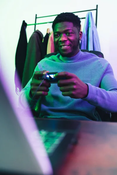 Homem afroamericano feliz jogando no computador jogo pad - tiro médio — Fotografia de Stock