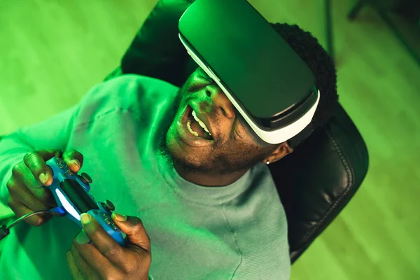 Gelukkig zwart man spelen VR headset blauw spel pad - portret — Stockfoto