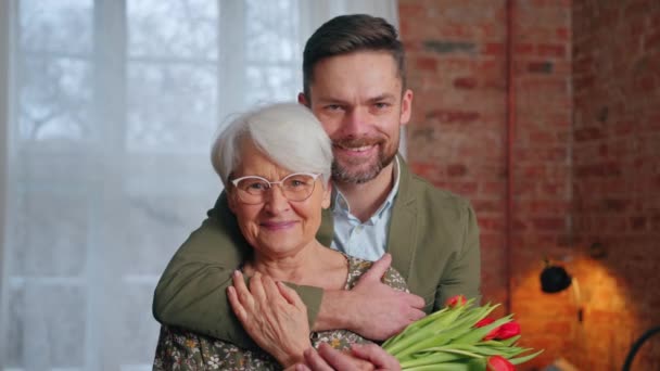 Caucasico elegantemente vestito uomo millenario di essere affettuoso con la sua anziana madre pensionato — Video Stock