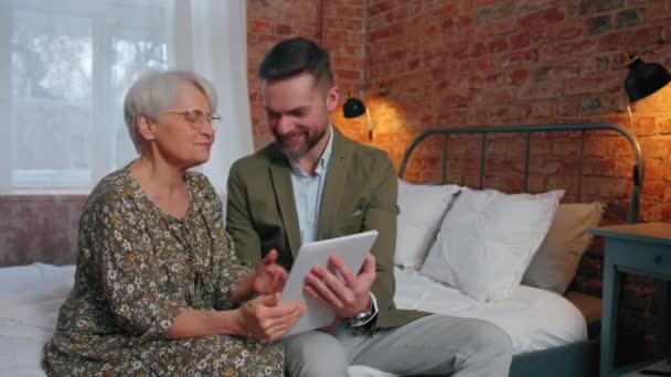 Parenti con gap generazionale seduto, incollaggio e guardare vecchie foto su tablet argento — Video Stock
