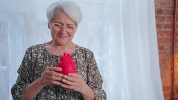 Бабушка кавказского происхождения, напоминающая об исследовании заболеваний сердца и заботе о здоровье — стоковое видео