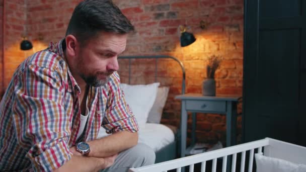Nowicjusz tata siedzi obok kołyski uczucie przerażony o jego niemowląt dzieci przyszłość — Wideo stockowe