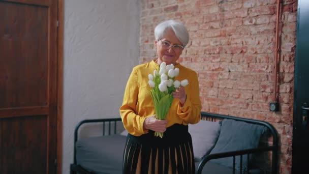 Пожилая седовласая женщина получает красивые белые цветы на День бабушки и дедушки — стоковое видео