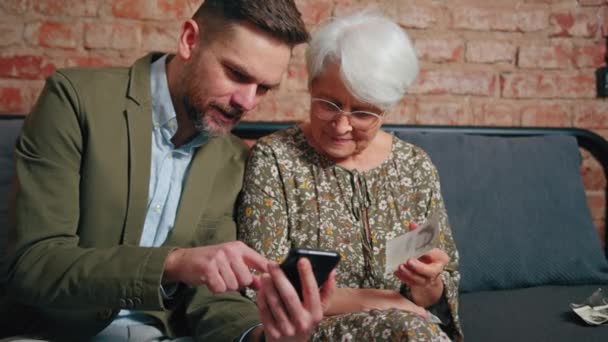 Europese familieleden met leeftijds- en generatieverschillen met foto 's op smartphone en op papier — Stockvideo
