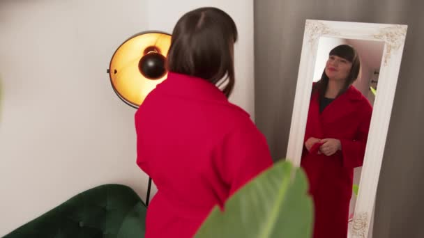 Specchio riflesso di una bella donna caucasica dai capelli castani che sorride e ride durante lo shopping di vestiti. — Video Stock