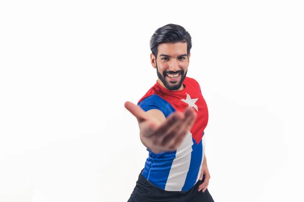 Porträtt av en latinamerikansk man bär Kuba flagga t-shirt och nå sin hand till kameran - isolerad på vit studio bakgrund — Stockfoto