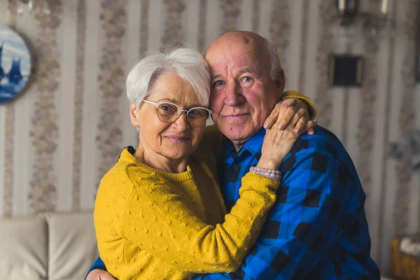 Portrait of an Caucasian European elderly couple smiling and embracing in vintage home interior — Stockfoto
