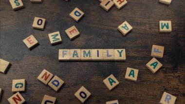 A word FAMILY - made of scattered wooden blocks with alphabet letters zoom in vocabulary game 