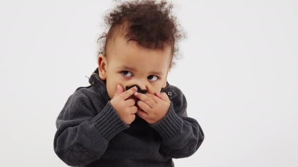 Маленький афроамериканський кучерявий хлопчик з великими чорними очима, одягнений в підроблені іграшкові вуса дивлячись в кіностудію знімок — стокове відео