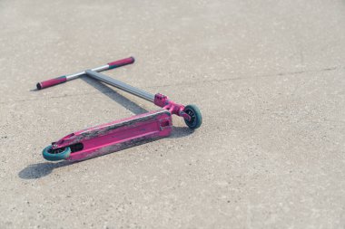 Yerdeki aktif yaşam tarzı konseptinde pembe bir scooter. 