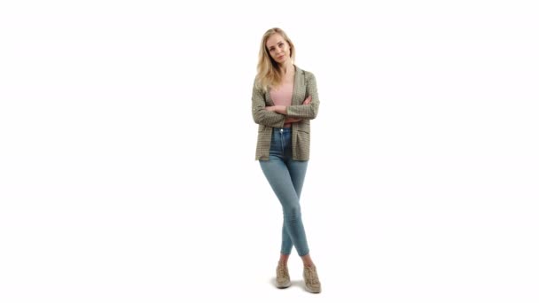 유럽의 매력적 인 금발 소녀가서 서 한 손으로는 웃으며 다른 손으로 는 데님스네케어와 재킷 스튜디오를 입고 있다. — 비디오