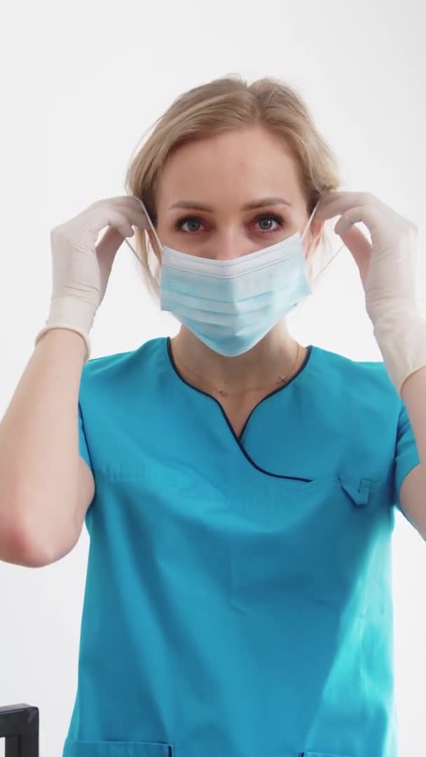 Vertical shot of a healthcare professional female worker. Putting on a surgical face mask before medical procedure. — Vídeos de Stock