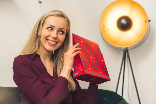 Ήρθε η ώρα να ανοίξει τα δώρα - μια ελκυστική ξανθιά ευρωπαϊκή κοπέλα κρατώντας ένα δώρο και χαμογελώντας μεσαίου closeup studio γυρίστηκε σε εσωτερικούς χώρους έννοια ευημερίας — Φωτογραφία Αρχείου