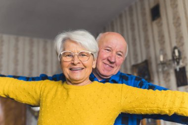 Kafkasyalı üst düzey heteroseksüel çift klasik oturma odalarında dans ediyor. Aktif emekli yaşlılar konsepti.