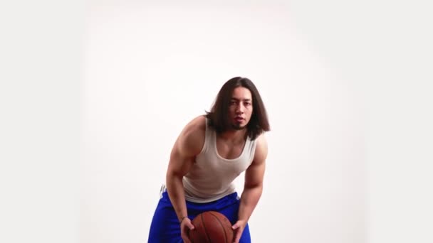 Slowmotion of young bearded Caucasian man playing with a basketball and showing it to the camera — Stock Video