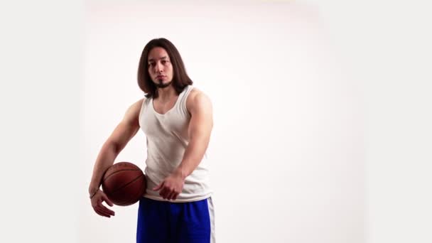 Pria berusia 20-an menunjukkan seperti sambil memegang bola basket di lengannya — Stok Video