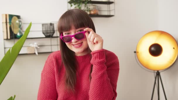 Young attractive woman holding her pink sunglasses posing and smiling — стоковое видео