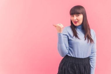 Heyecanlı genç beyaz kadın bir kenara, stüdyo pembe arka plan çekimleri izole edilmiş fotokopi alanı reklamları ve tanıtım konsepti 